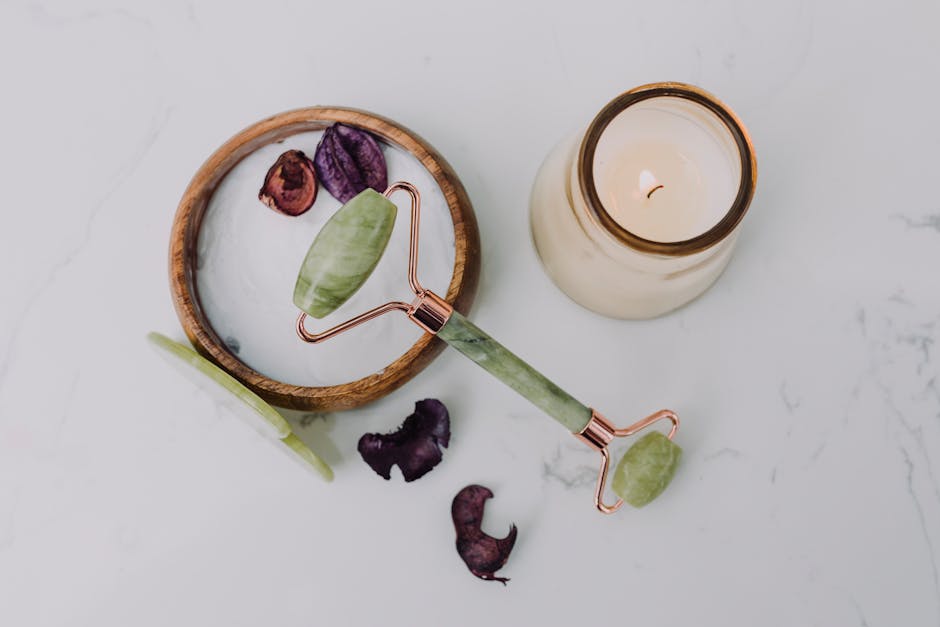 A relaxing flat lay of a jade roller and candle, perfect for a spa day at home