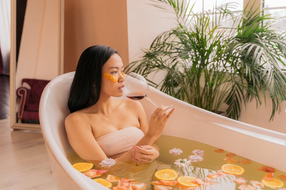 Woman enjoying a spa day with red wine and orange slices in a bathtub