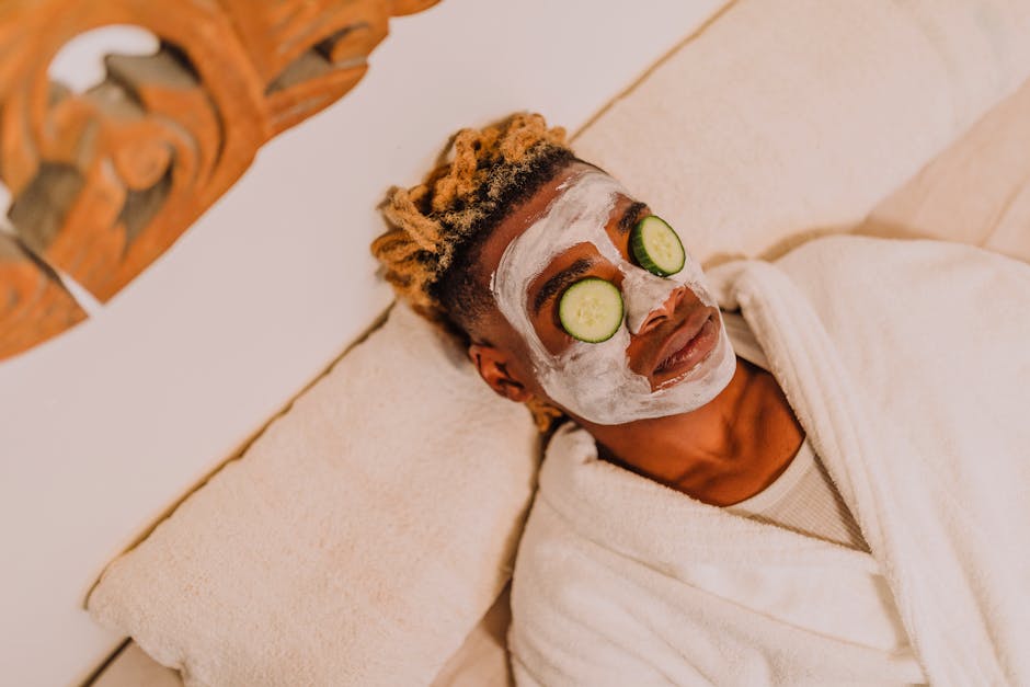 Person enjoying a relaxing spa treatment with cucumber facial mask for skincare